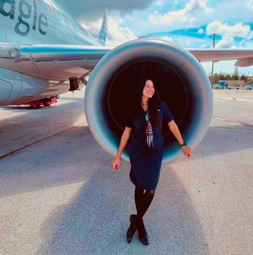 Image showing and ID90 member a flight attendant in front of airplane