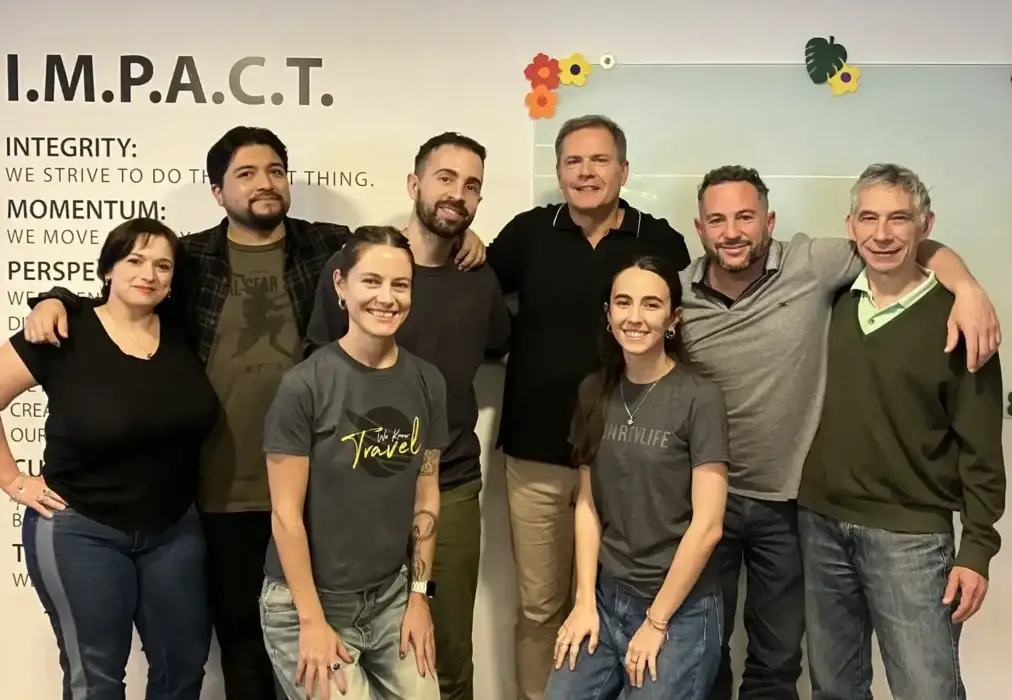 Group of ID90 Travel employees posing together in an office.
