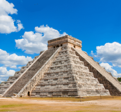 Ancient Mayan stone temple rising above green jungle landscape
