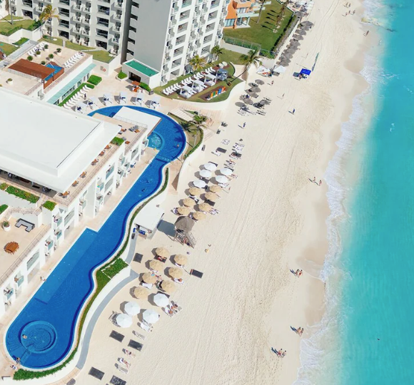 Oceanfront view of Emporio Cancun with a large pool overlooking the Caribbean Sea