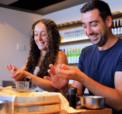 Participants learning to make sushi with a chef demonstrating preparation techniques