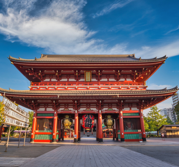 Traditional Japanese temple with wooden architecture and curved roof details in Tokyo.