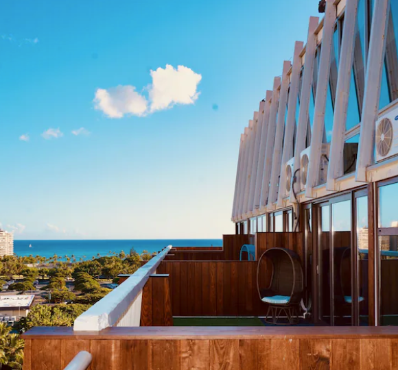 Hotel La Croix in Waikiki with modern high-rise architecture, palm trees, and city views near the beach