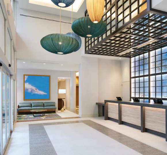 Waikiki Malia hotel exterior with tropical landscaping and high-rise building near Waikiki Beach