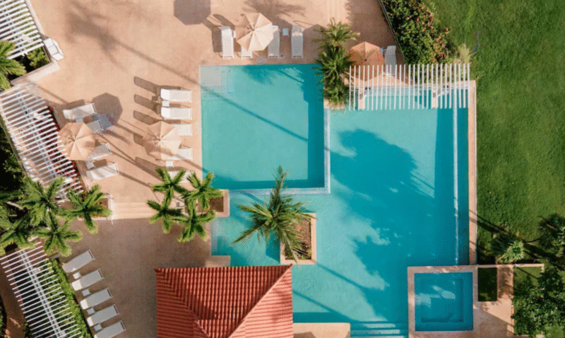 Luxury resort pool with crystal clear water, shaded cabanas, and modern lounge seating