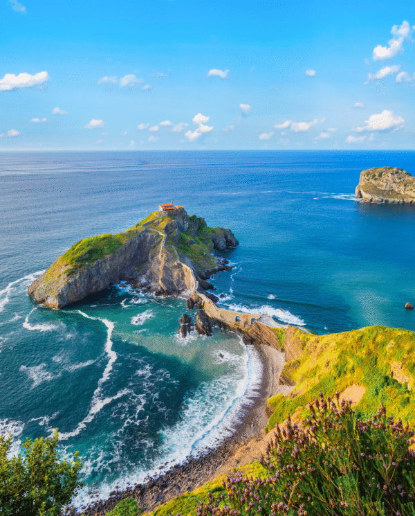 Aerial view of San Juan, Puerto Rico with colorful historic buildings, blue ocean coastline, and palm trees under a sunny sky