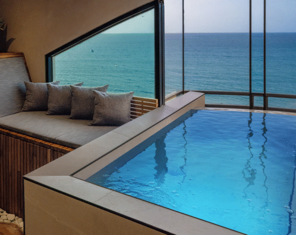 Resort-style swimming pool with palm trees, lounge chairs, and a relaxing vacation atmosphere