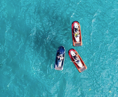 Person riding a jet ski across clear turquoise water on a sunny day