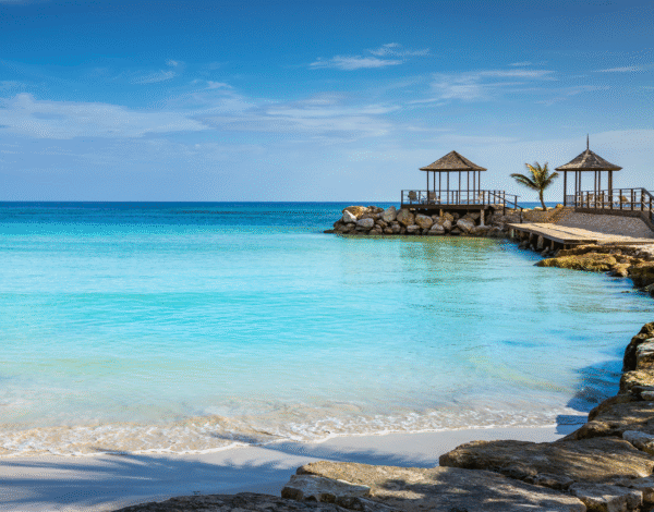 Soft white sand beach in Jamaica with clear turquoise water and blue sky