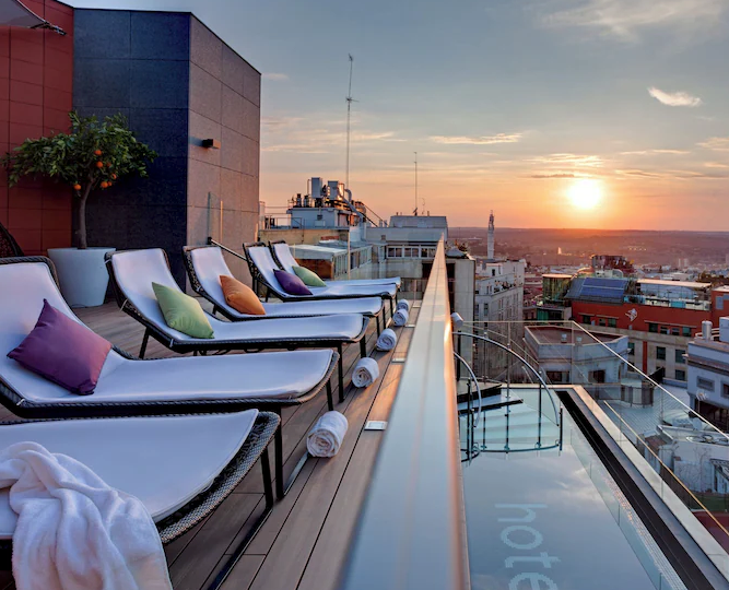 Exterior view of Hotel Indigo Madrid on Gran Vía with colorful modern facade and city street activity