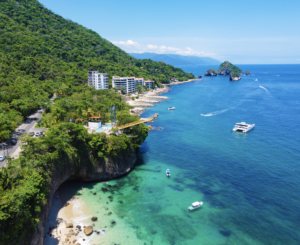 Scenic coastline where lush green mountains meet the sandy beaches of Puerto Vallarta