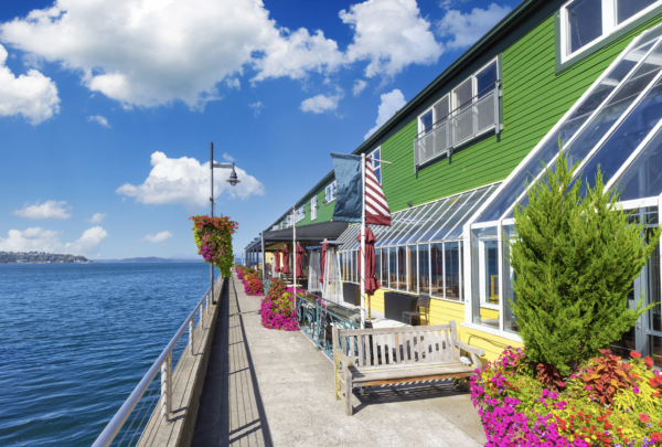 Waterfront cafe with outdoor seating overlooking the bay and passing boats