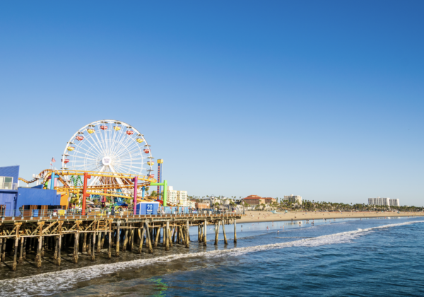 Ferris wheel by the waterfront with ocean views and colorful lights