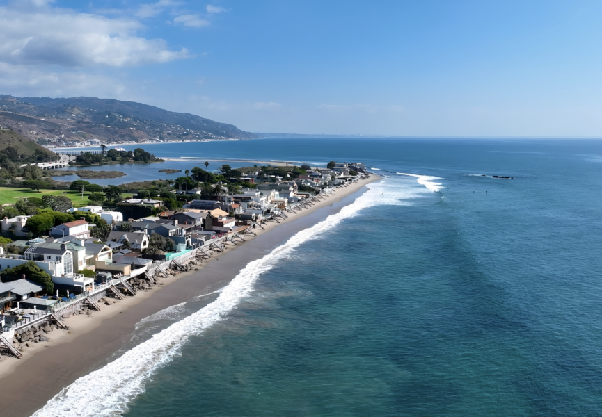 Sandy beach with ocean waves and people enjoying the coastline