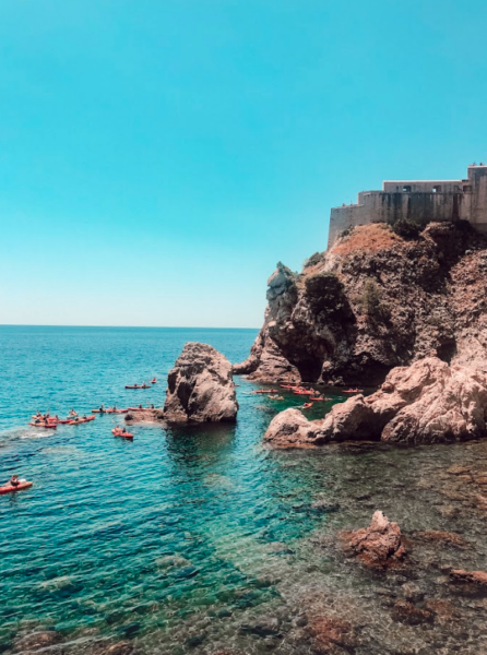 Scenic view of bright blue waters surrounded by mountains under a clear sky